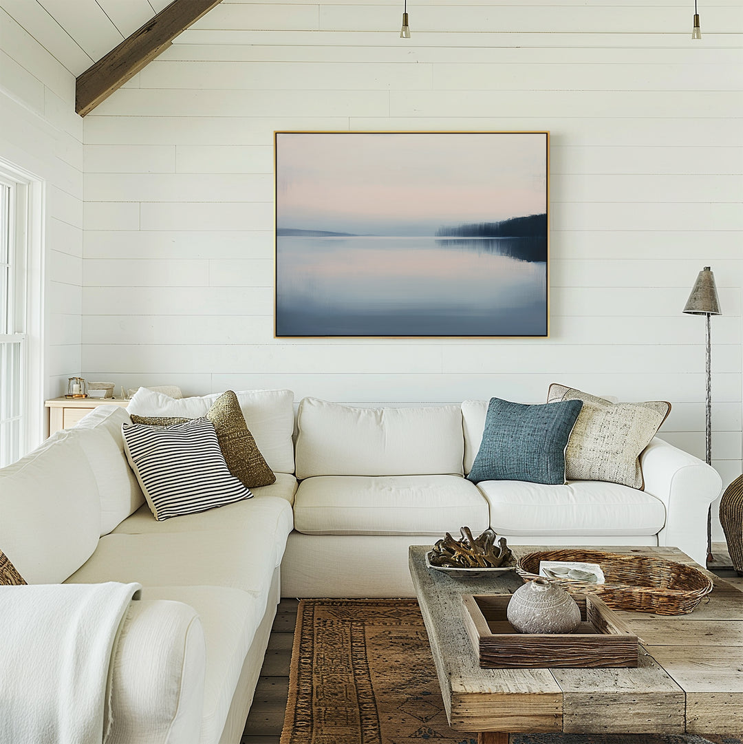A cozy living room with white shiplap walls, a spacious white sectional topped with assorted pillows, a wooden coffee table decorated with accents, and the calming Echo Lake Canvas Art – Horizontal displayed above the sofa.