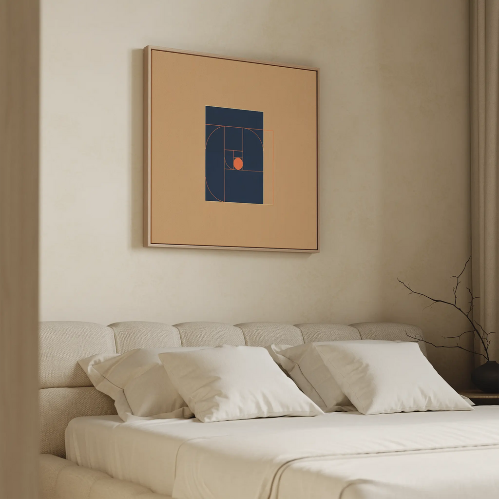 A beige bedroom features a tufted headboard, white bedding, and the Ember Point Canvas Art with bold blue and orange shapes above the bed. A bare branch in a vase on the nightstand enhances the serene modern look.