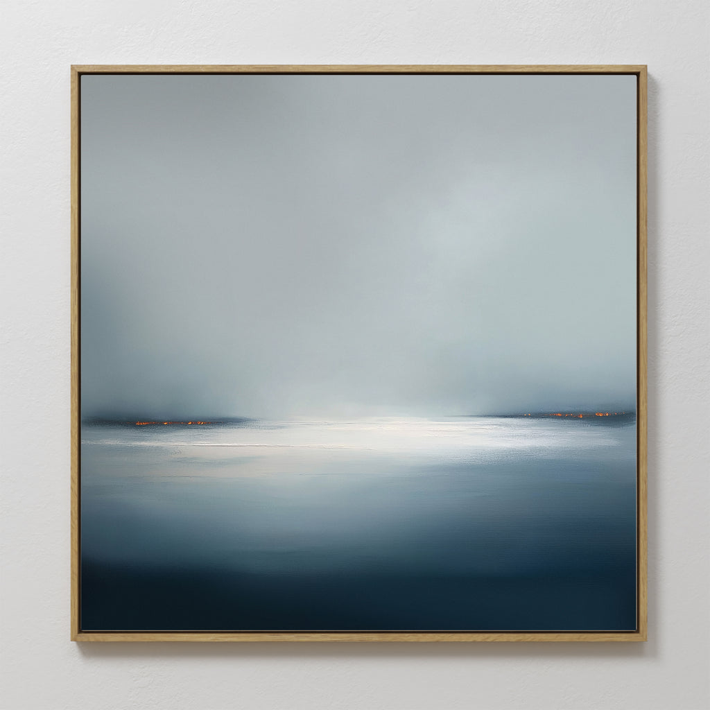 Emberline Stillness Canvas Art is a framed abstract seascape with soft blue and gray tones, bright water, and distant orange lights—ideal minimalist wall decor for modern interiors or calming bedroom spaces.