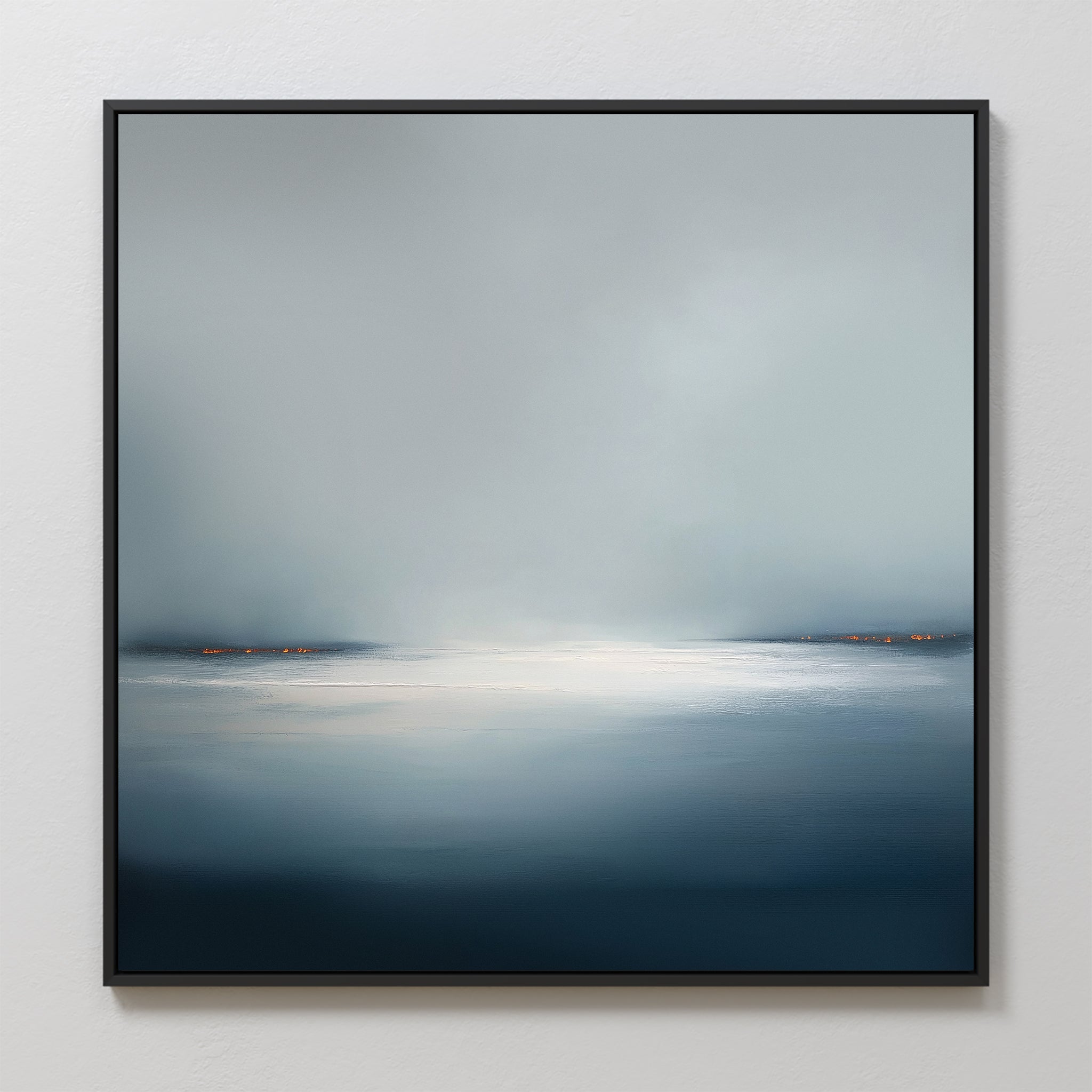 Emberline Stillness Canvas Art features a serene, misty landscape with calm water and soft orange shoreline lights. Its cool blue and gray tones bring minimalist, tranquil style to any modern interior.