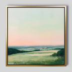 Evening Hues Abstract Canvas Art features a tranquil landscape with green fields, hills, a winding river, and a blue-peach pastel sky. The elegant gold frame makes it perfect for adding style to your living room against a light gray wall.
