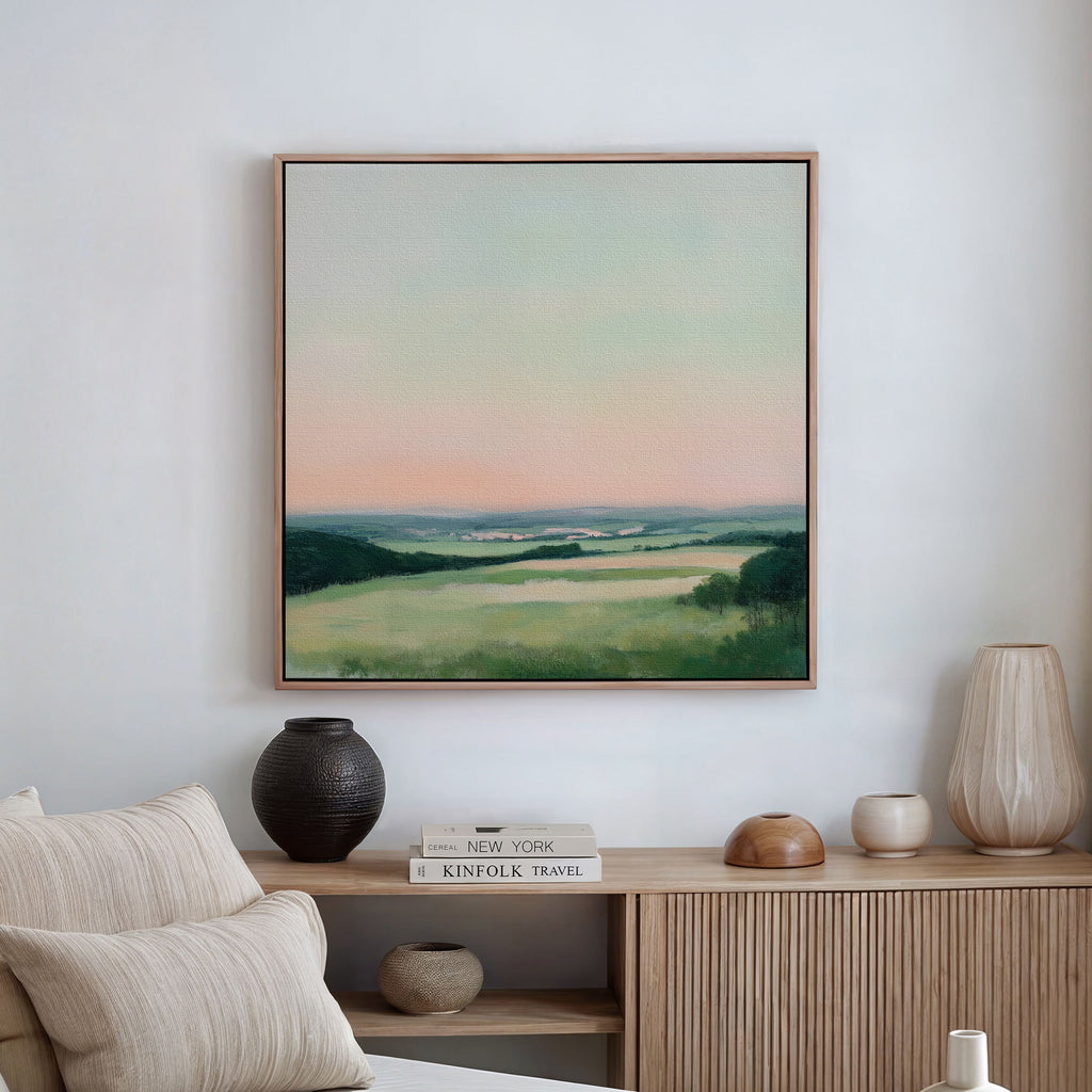 The Evening Hues Abstract Canvas Art hangs above a wooden sideboard adorned with vases, a candle, and stacked books, creating a serene setting with neutral tones and minimalist living room decor.