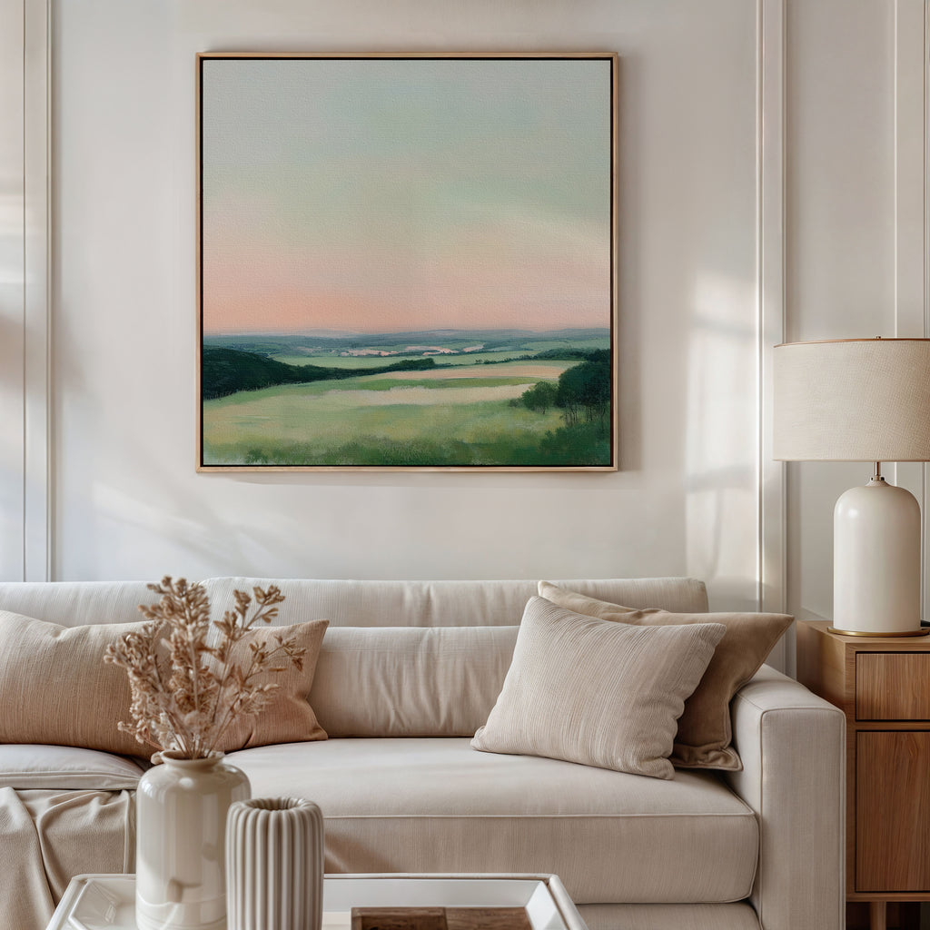 A modern living room with a beige sofa, neutral pillows, dried flowers in a vase, a table lamp, and the Evening Hues Abstract Canvas Art featuring pastel skies and green fields—perfect for elevating your decor.