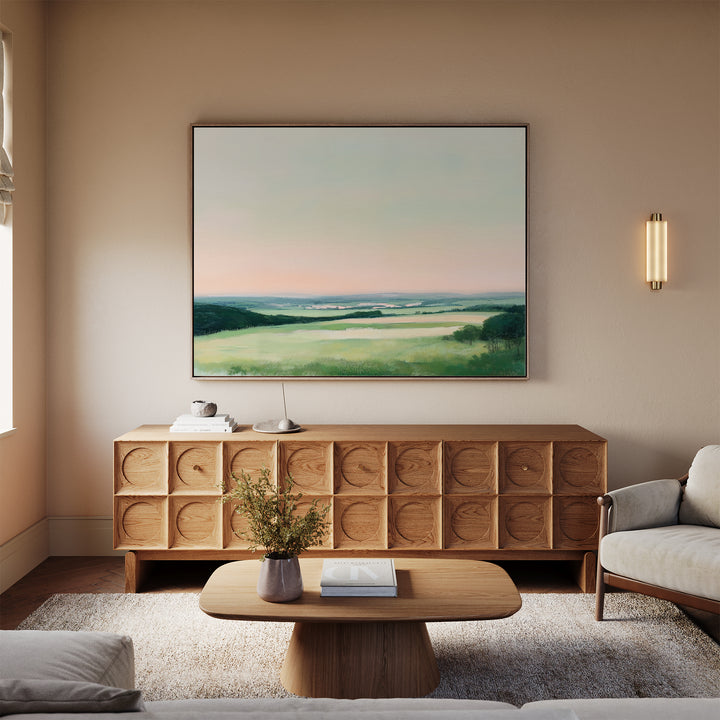 A modern living room with a light wood sideboard, Evening Hues Canvas Art – Horizontal above it, a low wooden coffee table, beige sofa, and soft neutral decor all bathed in natural light.