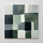 The Evergreen Abstract Canvas Art features a grid of overlapping rectangles in green, gray, white, and black with visible brush strokes and textured edges on a square canvas displayed against a white wall.