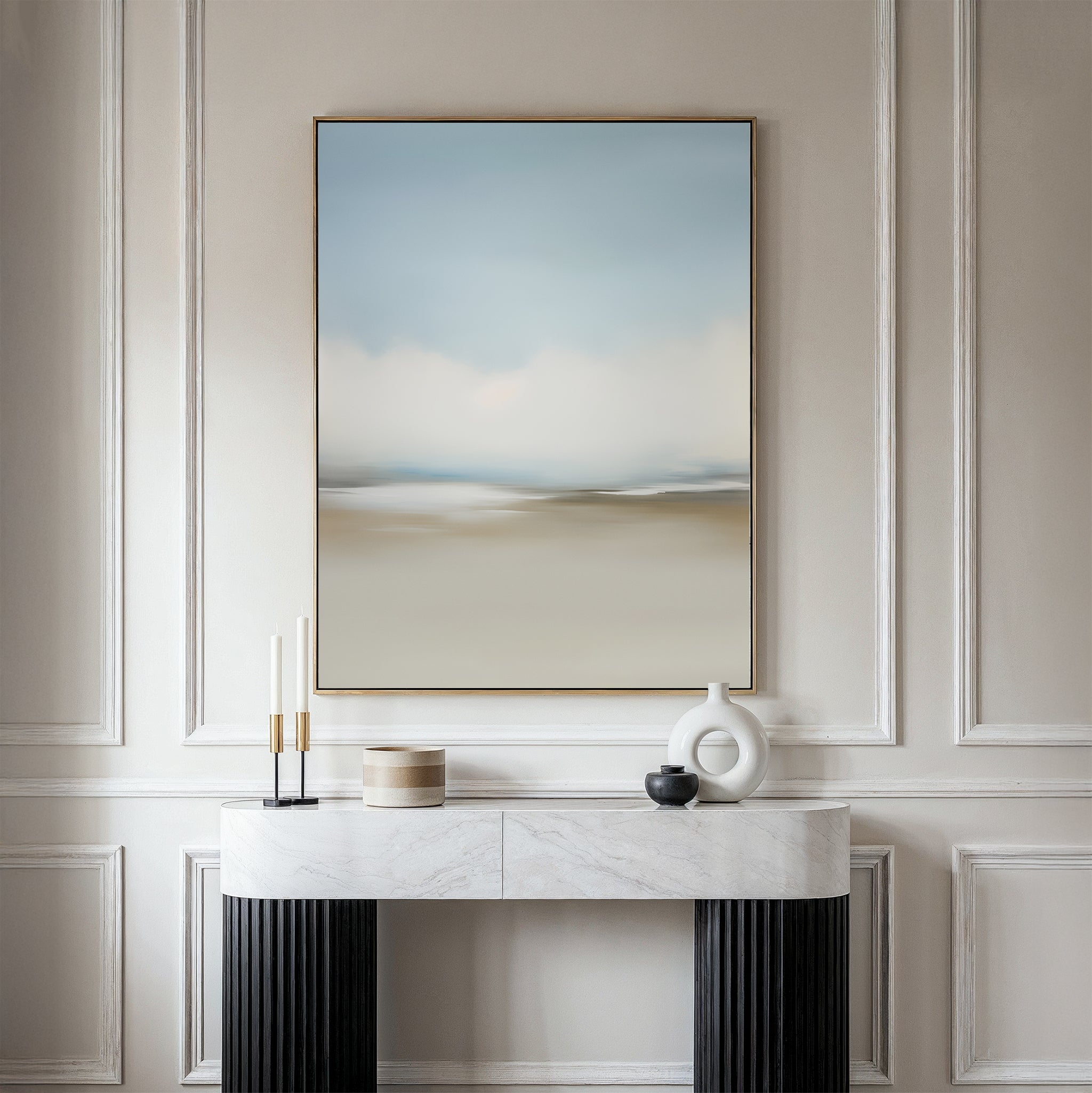 The Faded Silence Canvas Art in soft blue and beige tones hangs on a white wall above a marble console table, styled with minimalist decor such as candles, a round box, and modern ceramic vases.