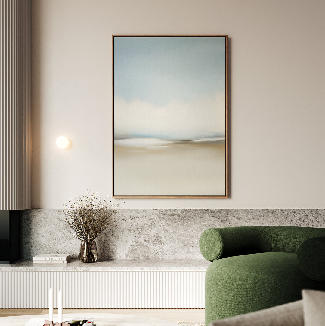 A modern living room featuring a green curved sofa, marble accents, round wall light, minimalist wall art, a vase with dried branches, and the Faded Silence Canvas Art—a large abstract landscape in soft blue, beige, and white tones.
