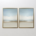 The Faded Silence Set of 2 features abstract landscape prints in soft blue, white, and beige tones, evoking a tranquil, cloudy sky—ideal minimalist wall art displayed together on a white wall.