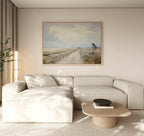 A modern living room featuring a light beige sectional sofa, minimalist decor, a wooden coffee table with a black bowl, a potted plant, and the Far Light Canvas Art displayed above the sofa.