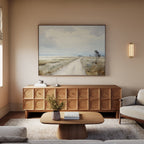 A cozy living room features a wooden coffee table, sculpted wooden sideboard, neutral sofa, wall-mounted sconce, and minimalist decor topped off with the Far Light Canvas Art above the sideboard.