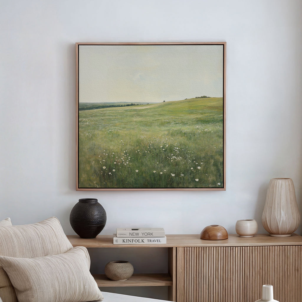 The Floral Meadow Canvas Art hangs above a wooden sideboard adorned with neutral vases and books. In the foreground, a beige sofa with cream pillows completes the calm, minimalist living room decor.
