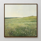 The Floral Meadow Canvas Art features a sunlit grassy field with white wildflowers, gentle hills, and a serene atmosphere—an ideal framed wall art print for enhancing your living room decor.