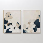 The Floral Serenity Set of 2 features framed abstract flower wall art in neutral beige, white, and navy tones with soft shapes on a light background—ideal minimalist decor for a stylish living room.