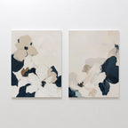 The Floral Serenity Set of 2 features abstract floral wall art in soft white, beige, taupe, and navy blue tones. Large overlapping petals create a minimalist look—ideal for elegant living room decor. Each canvas hangs beautifully side by side.