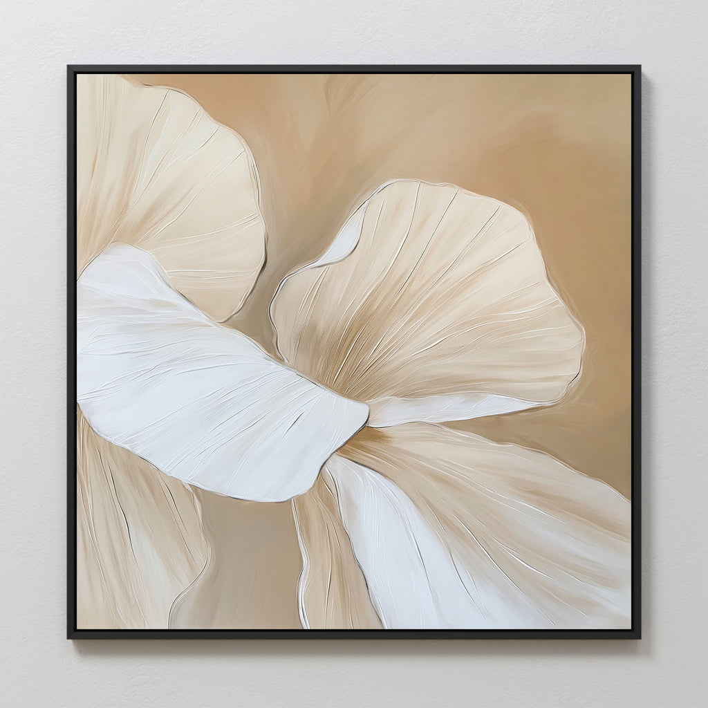 Floral Whisper Abstract Canvas Art displays two abstract cream and beige flower petals with fine white lines on a soft tan background. This minimalist canvas print comes framed in black, perfect for elegant display on a light-colored wall.