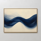 Flowing Indigo Canvas Art features a ribbon-like wave in deep blue on a light beige background, framed in slim gold—ideal modern wall art to enhance minimalist spaces or add style to your living room decor.