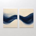 The Flowing Indigo Set of 2 features square canvases with abstract navy blue waves on a light beige background, creating striking modern wall art that enhances minimalist interiors and living room decor.