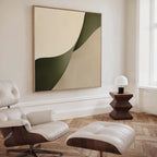 A modern living room featuring a white leather lounge chair and ottoman, wooden side table with a white lamp, parquet floors, and the Forest Flow Canvas Art in green and beige—perfect for minimalist decor.
