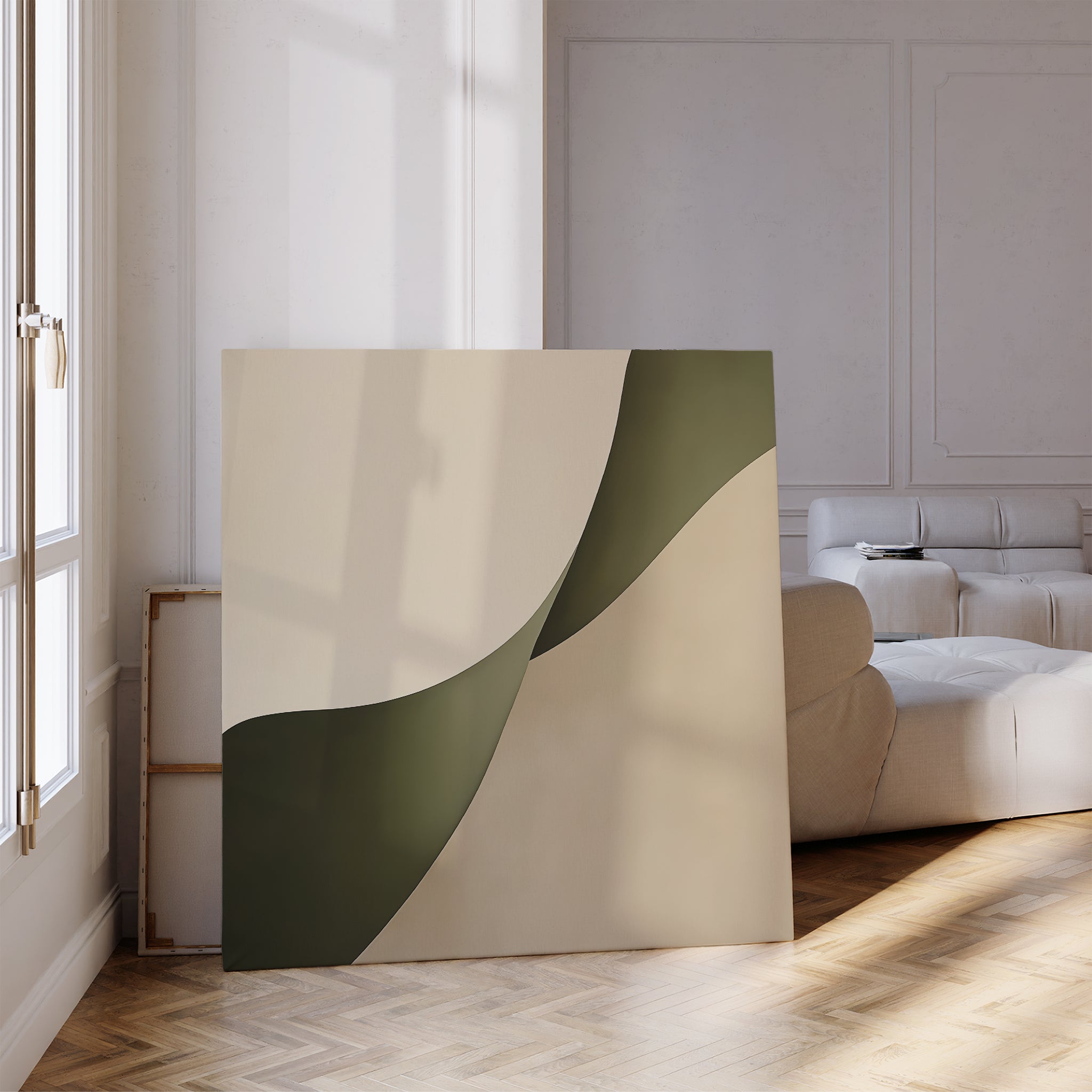 The Forest Flow Canvas Art, featuring beige and olive green curves, leans against the wall of a bright modern living room with parquet floors and a white sofa, bringing a minimalist touch to the space.