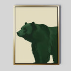 Forest Guardian Canvas Art features a minimalist green bear in profile on a light beige background, framed in gold. This modern rustic piece captures wilderness wall art with the bear facing left and filling most of the frame.