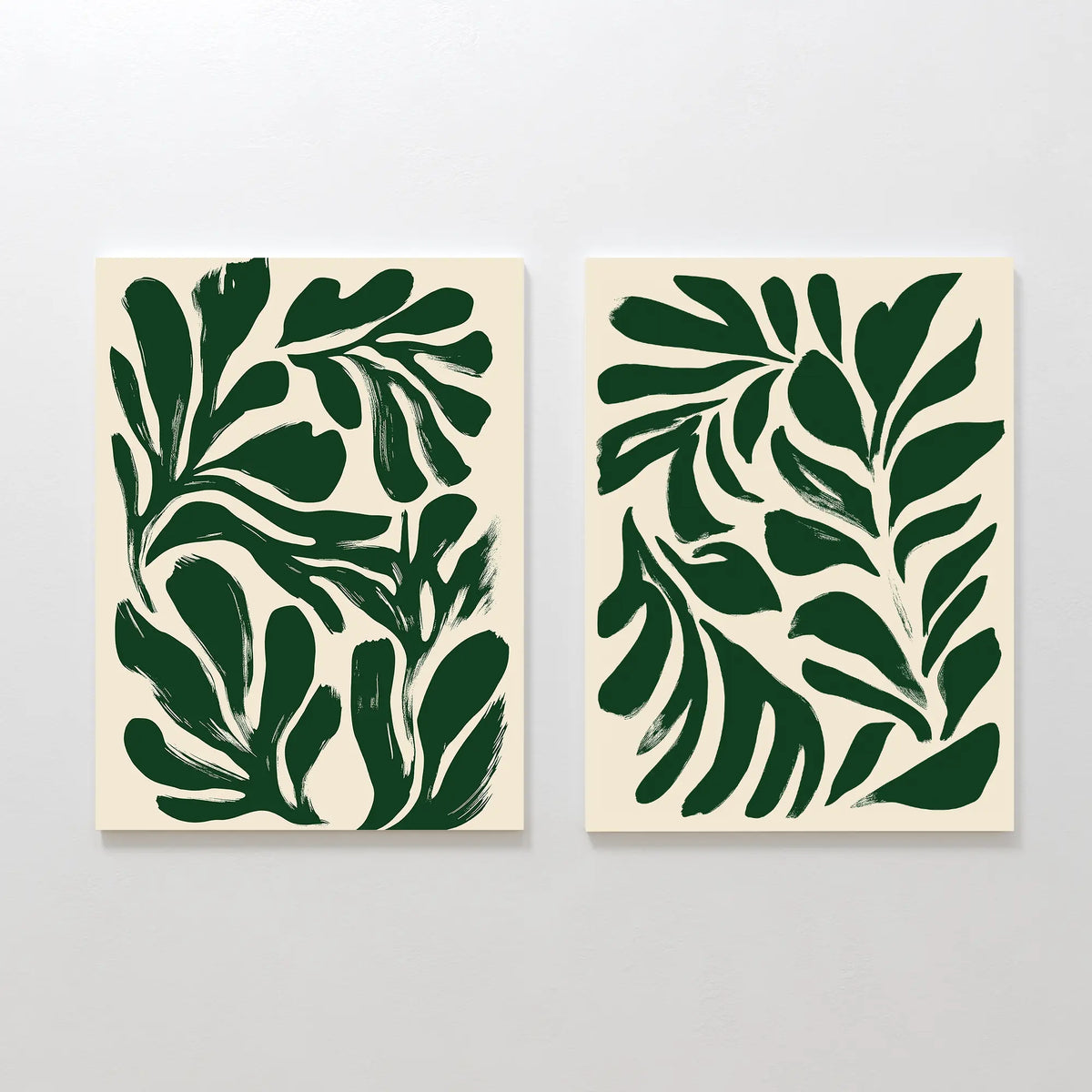 The Forest Leaves Set of 2 features bold, dark green abstract leaf prints on off-white backgrounds in a modern brushstroke style—perfect wall art to create a Nordic Park vibe in any space.