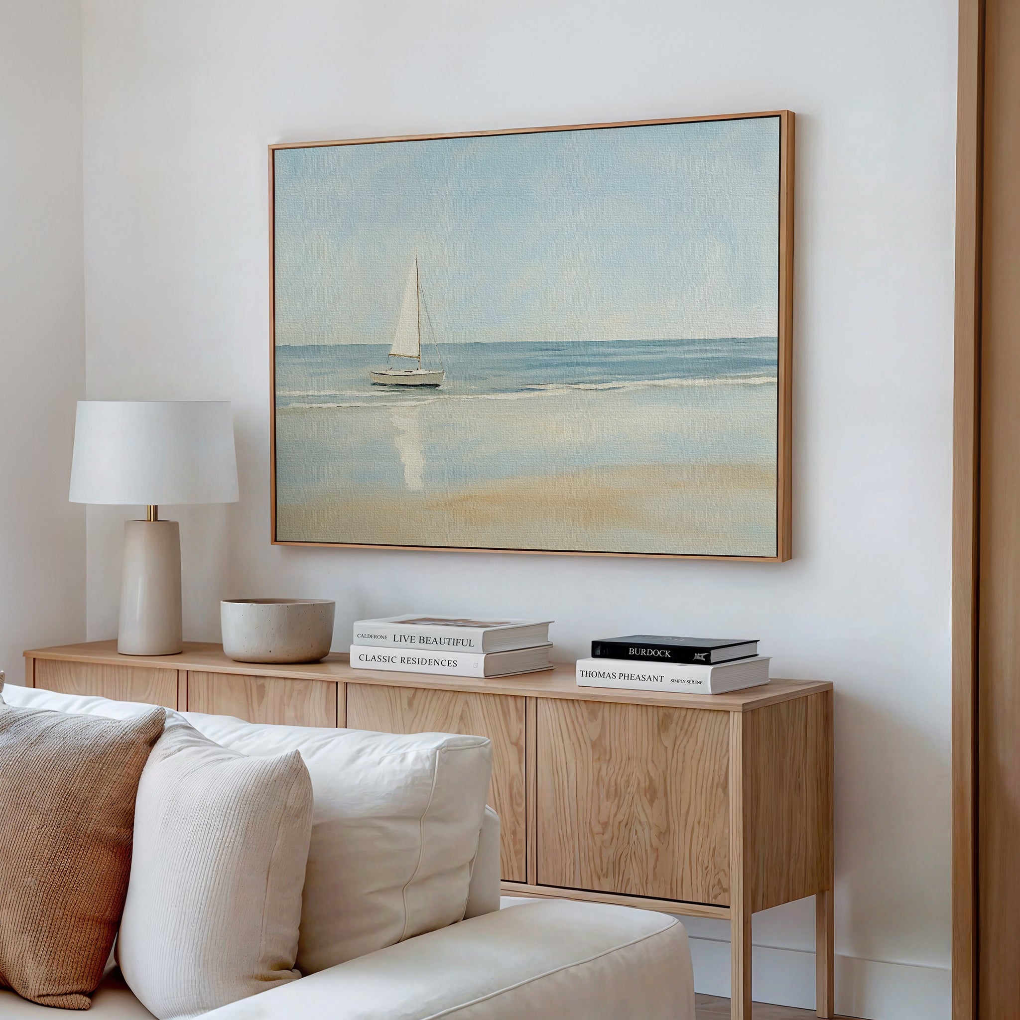 A modern living room featuring the Freedoms Call Canvas Art above a cream sofa, paired with a light wood sideboard, books, bowls, and a lamp—ideal for those who love serene, tranquil home decor.