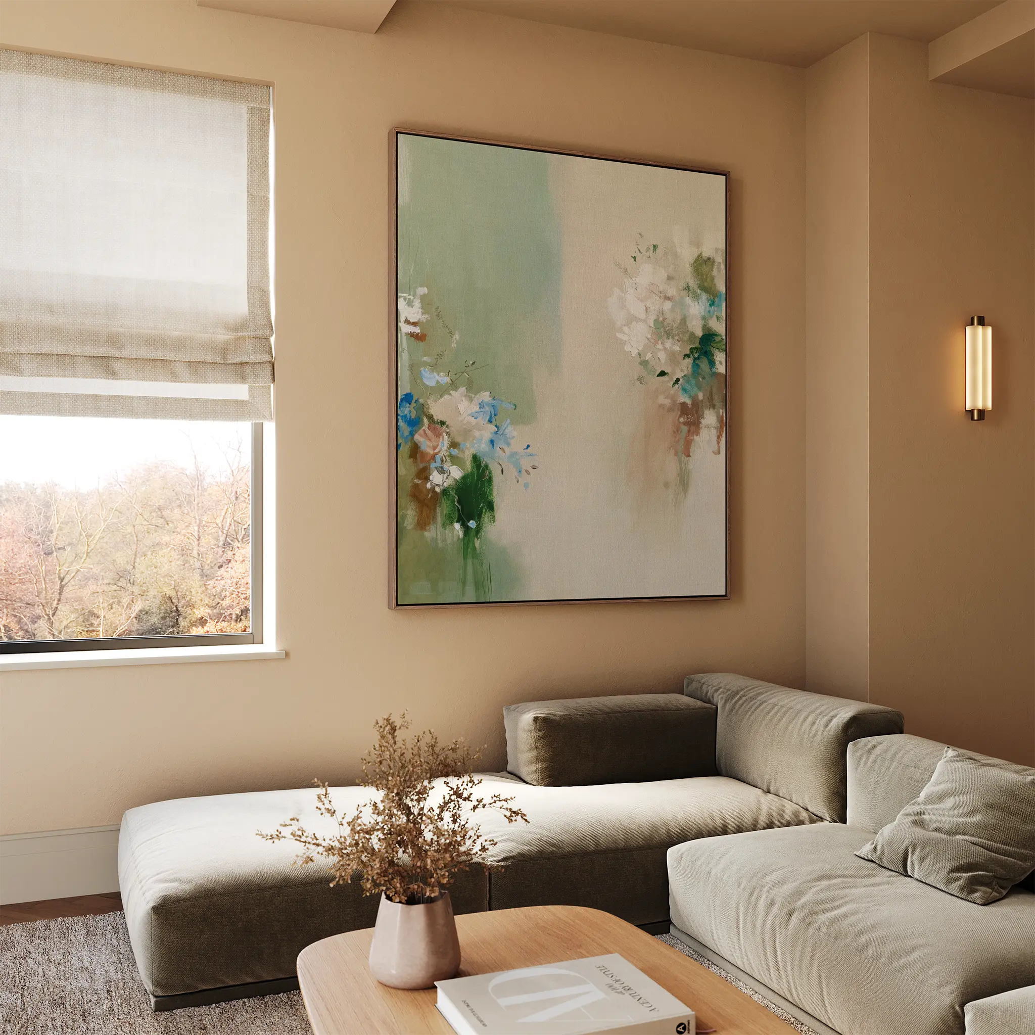 A modern living room with a beige sectional sofa, wooden coffee table with dried flowers, elegant decor accents, and a window with a Roman shade framing tree views. The wall features the Garden Bloom Canvas Art as a focal point.