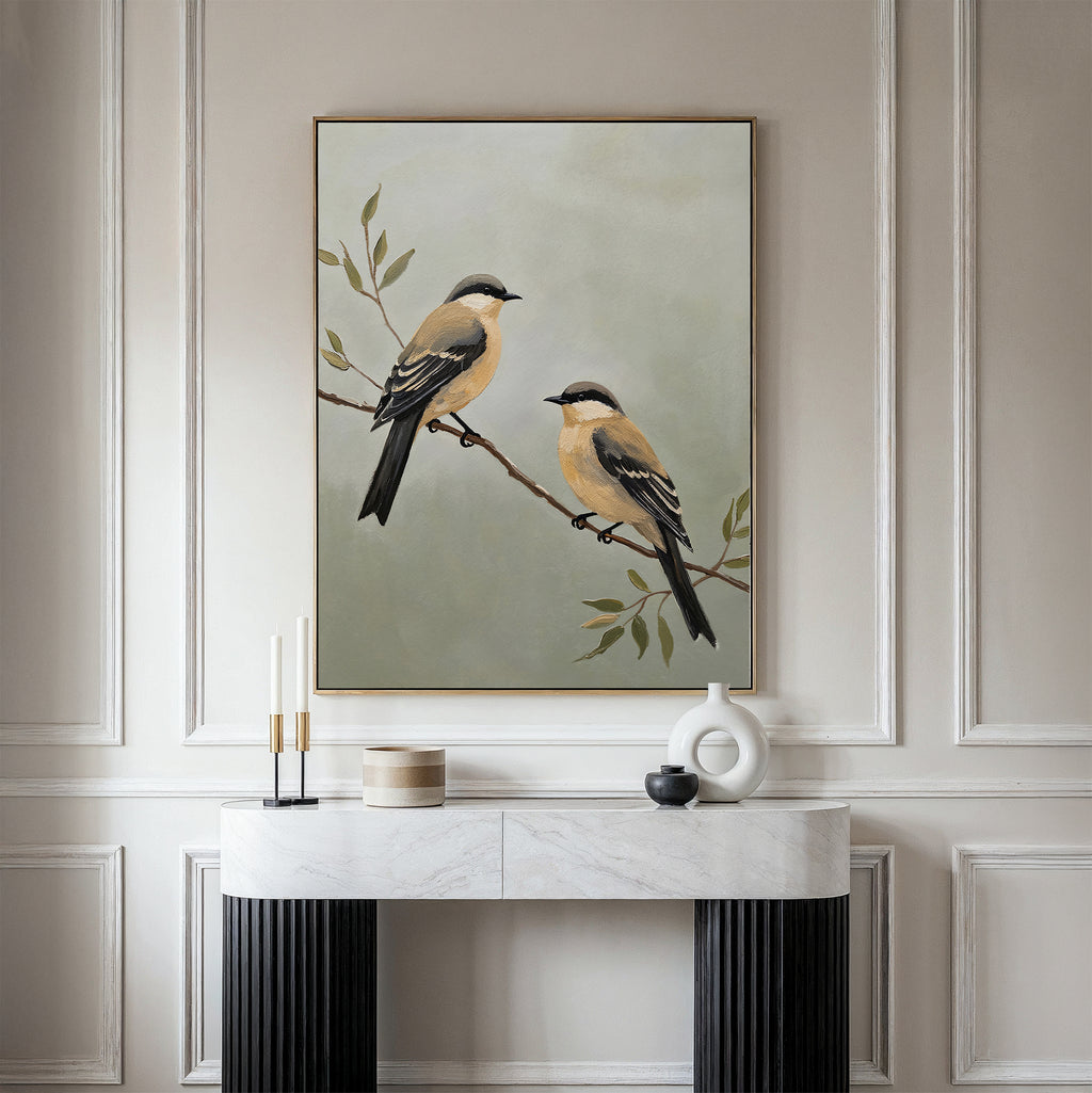 The Garden Pair Canvas Art, featuring two perched birds, hangs above a white marble console table on an ornate paneled wall, bringing elegant charm to your living room alongside modern ceramic vases and candles.