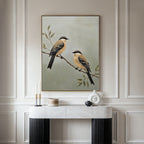 The Garden Pair Canvas Art, featuring two perched birds, hangs above a white marble console table on an ornate paneled wall, bringing elegant charm to your living room alongside modern ceramic vases and candles.