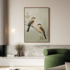 The Garden Pair Canvas Art, featuring two yellow and brown birds on a branch, hangs above a marble shelf, bringing Nordic Park charm to the living room alongside a green curved sofa and dried flowers in a vase.