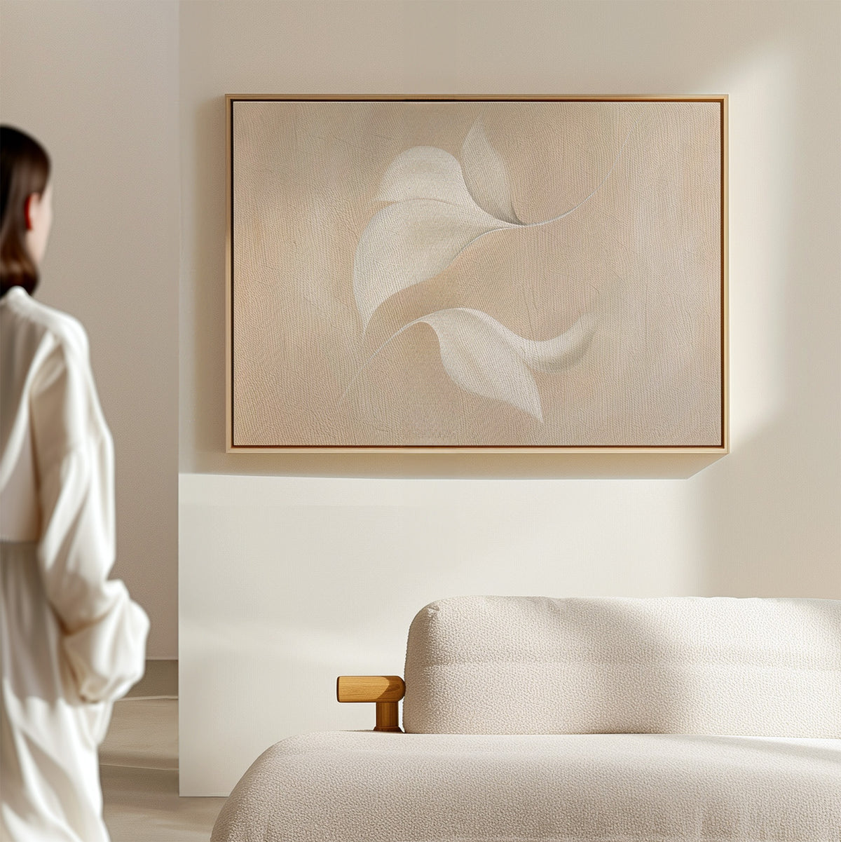 A person in white stands in a minimal, light-filled room with a beige sofa and the Garden Spectrum Abstract Canvas Art—a perfect choice to elevate your living room decor.