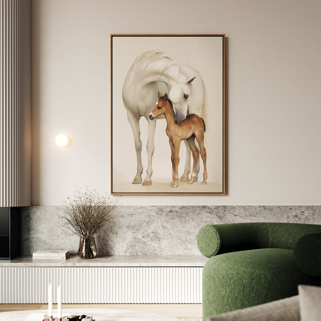 A modern living room features the Gentle Bond Canvas Art—a large framed painting of a white horse and brown foal—above a marble shelf, paired with a green curved sofa and neutral accents like a vase with dried branches.