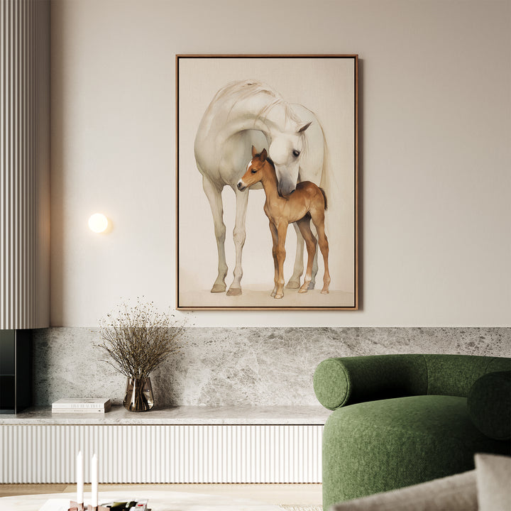 A modern living room features the Gentle Bond Canvas Art—a large framed painting of a white horse and brown foal—above a marble shelf, paired with a green curved sofa and neutral accents like a vase with dried branches.