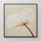 Gentle Poppy Canvas Art features a minimalist floral design with a single white-petaled flower and dark stem on a light beige background, framed in black and displayed on a pale wall.