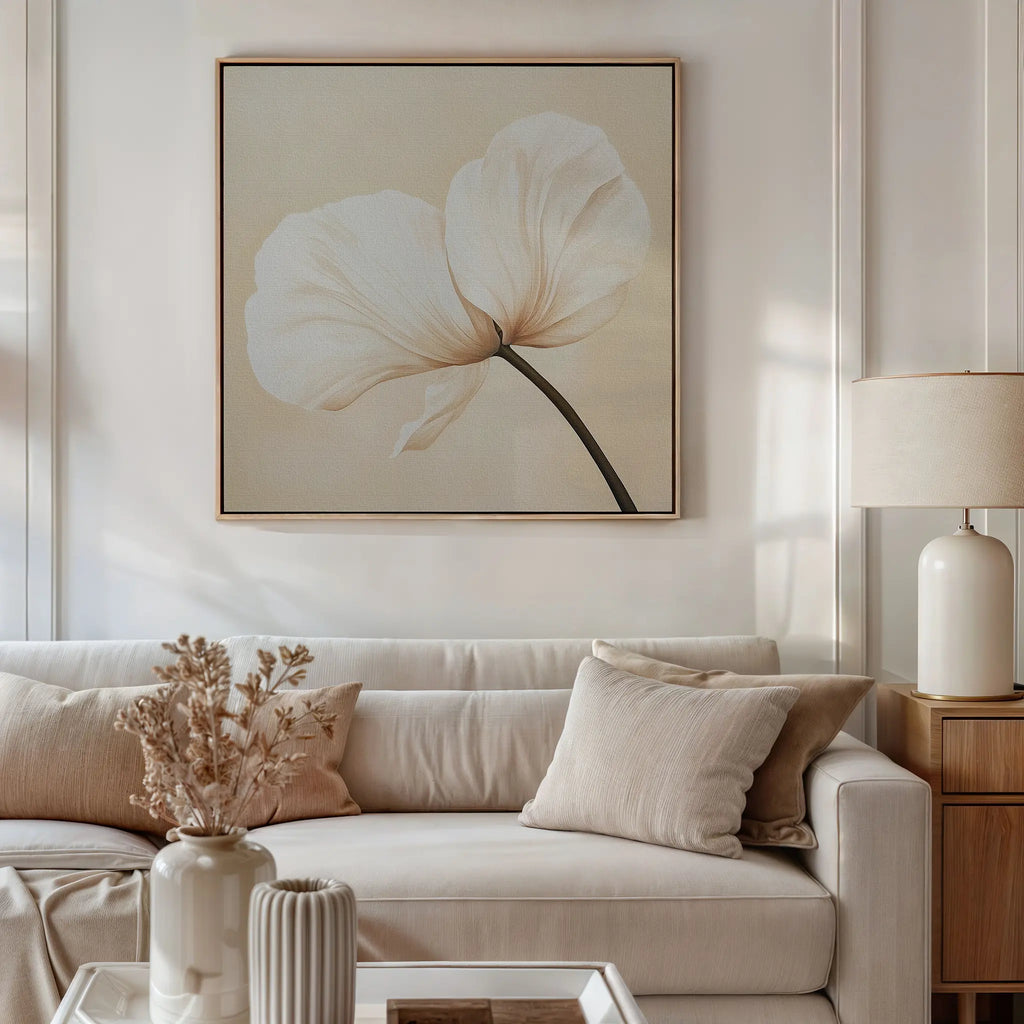 A bright, elegant living room with a beige sofa, neutral pillows, side lamp, dried flower vase, and the Gentle Poppy Canvas Art—featuring a delicate white flower on a light background—perfect for minimalist decor.