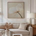 A bright, elegant living room with a beige sofa, neutral pillows, side lamp, dried flower vase, and the Gentle Poppy Canvas Art—featuring a delicate white flower on a light background—perfect for minimalist decor.
