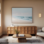 A cozy living room with a light sofa, wooden coffee table, and geometric-patterned sideboard. The Gentle Surf Canvas Art above the sideboard brings a calm, serene vibe—perfect inspiration for your living room decor.