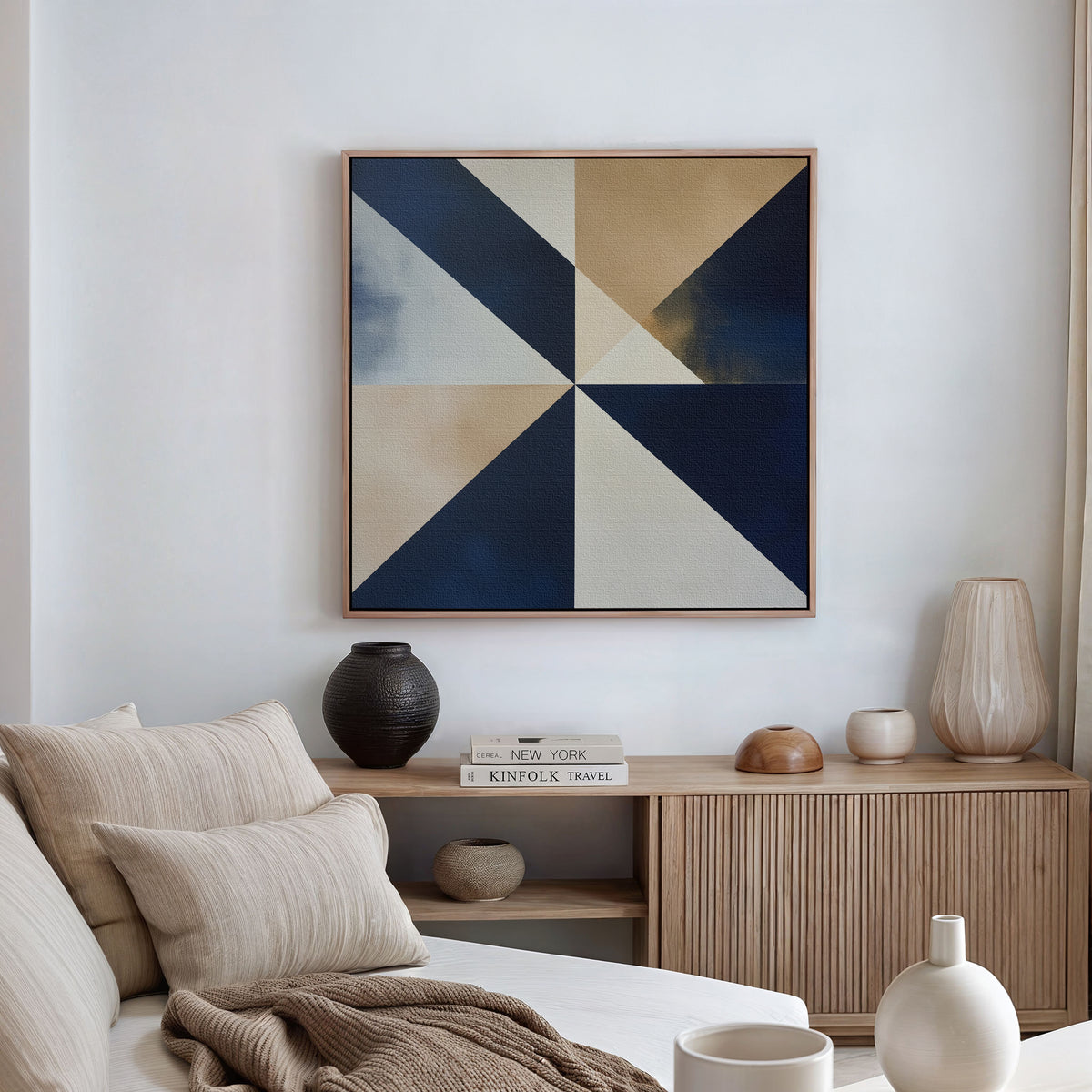 A modern living room featuring a beige sofa with striped pillows, a wooden sideboard with decorative objects and books, and the Geometric Night Canvas Art in blue, beige, and white tones displayed on the wall above.