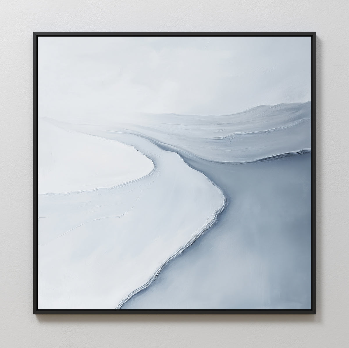 Glacial Flow Canvas Art features cool tones with a winding river through snowy hills beneath a pale sky. Framed in black, this minimalist abstract piece brings serene elegance to modern living room decor on light walls.
