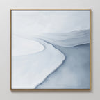 Glacial Flow Canvas Art features a minimalist landscape in soft white and blue tones, with smooth lines and subtle texture evoking a winding river. This serene piece comes in a simple gold frame, ideal for modern living room decor.