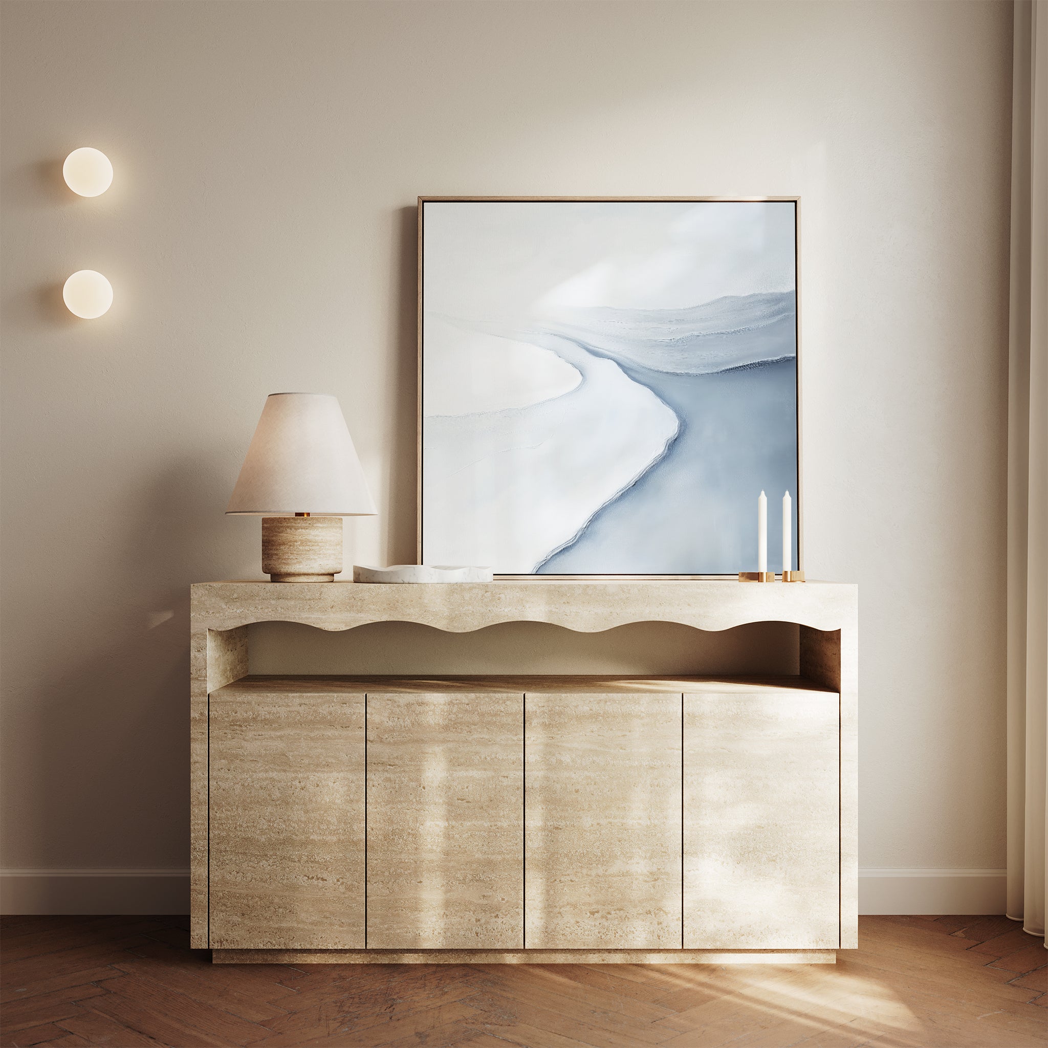 A modern console table with a wavy design displays a lamp, two tall candles, and the Glacial Flow Canvas Art in soft blue and white; two round wall lights and sheer curtains finish the modern living room decor.
