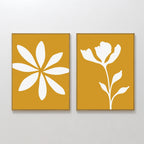 The Golden Bloom Set of 2 features modern wall art: one print with a white abstract eight-petal flower on mustard yellow, and the other with a white silhouette of a blooming flower and leaves—perfect for any space.