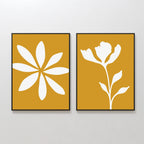The Golden Bloom Set of 2 features framed minimalist floral prints with white silhouettes on a mustard yellow background, hung side by side to create striking modern wall decor.