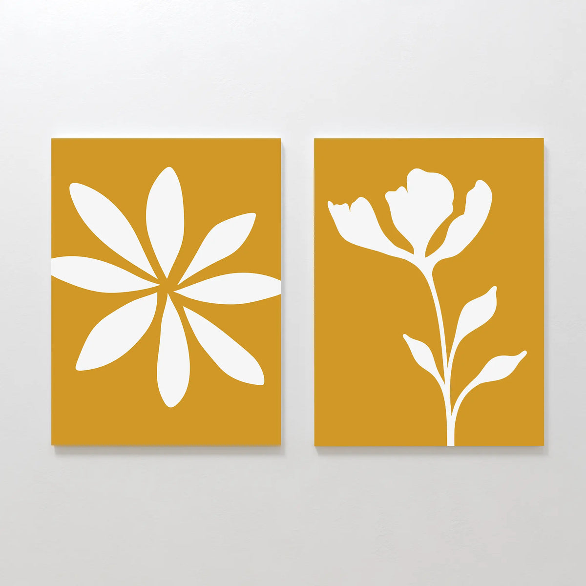 The Golden Bloom Set of 2 features yellow canvases: one with a white abstract eight-petal flower, the other with a white blooming stem—ideal as modern wall decor or striking floral art.