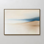 The Golden Drift Canvas Art – Horizontal features minimalist abstract brushstrokes in beige, cream, and blue, evoking tranquil sand dunes and water—perfect for adding serene style to your living room with its sleek dark frame.
