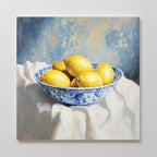 The Golden Fruit Canvas Art features a blue and white patterned bowl with six yellow lemons on a white cloth, set against a soft blue and yellow background—perfect vintage decor for your home.