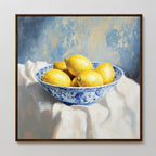 Golden Fruit Canvas Art: A framed canvas print featuring six vibrant yellow lemons in a blue and white bowl on a white cloth with a blue-toned background—perfect rustic wall art to brighten your space.