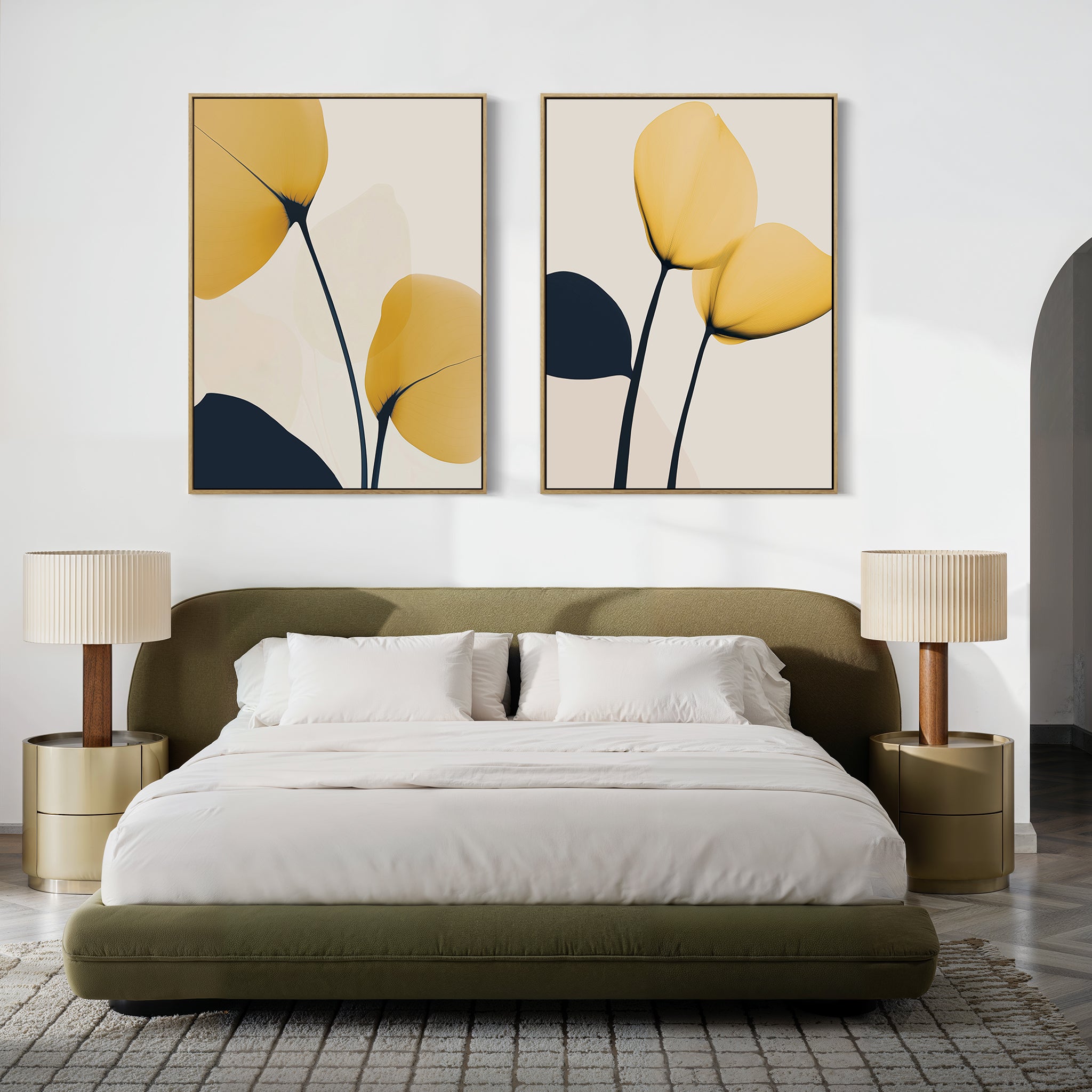 A modern bedroom with a green upholstered bed, white bedding, beige nightstands and lamps, and the Golden Leaves Set of 2 wall art featuring abstract yellow and navy petals above the bed.