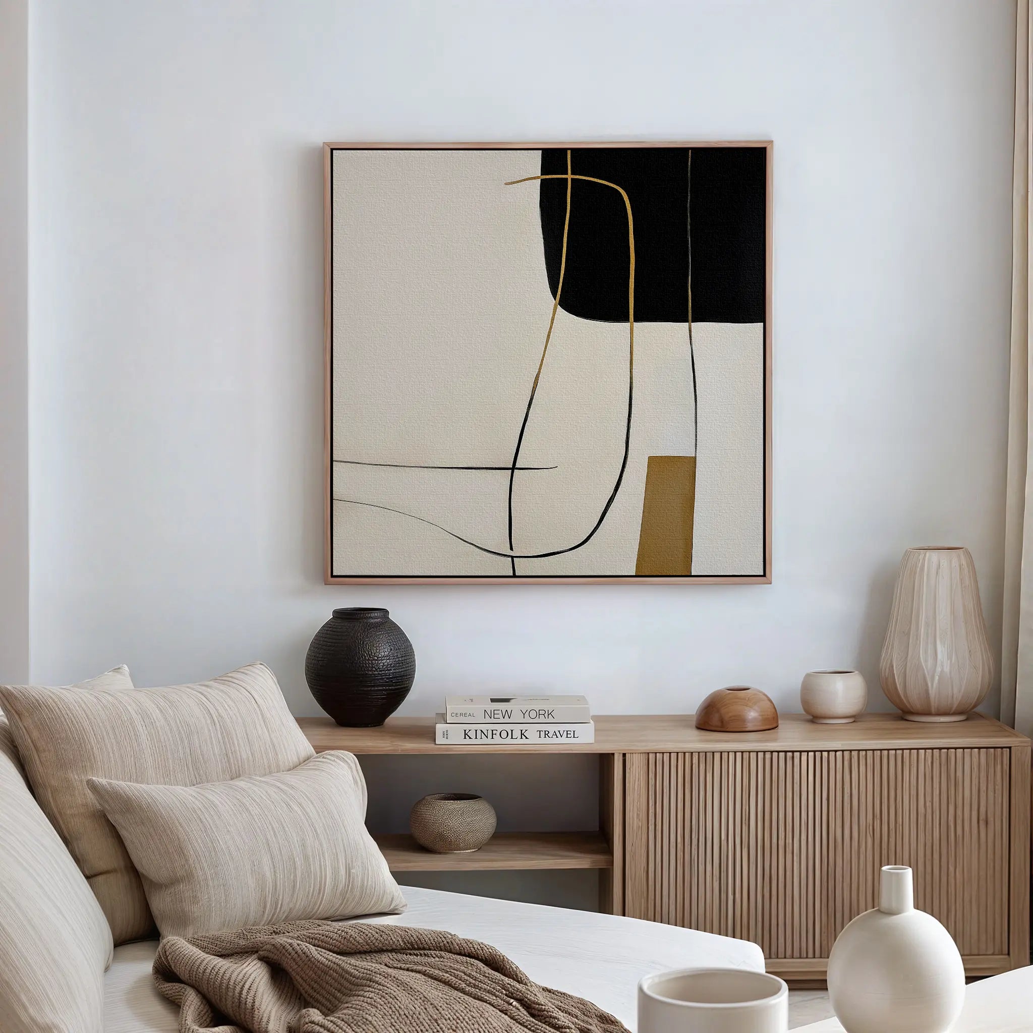 Minimalist living room with a beige sofa, neutral cushions, wooden sideboard, ceramic vases, books, and the Golden Thread Canvas Art. Simple and modern decor reflects the clean lines of Nordic Park style minimalism.