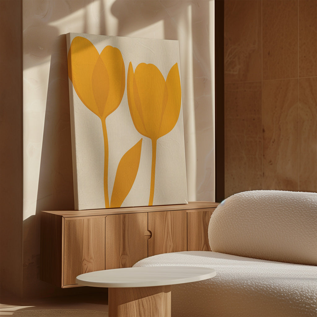 The Golden Tulips Abstract Canvas Art, featuring two yellow tulips on white canvas, rests on a wooden cabinet beside a textured white sofa and round table, adding elegance to a softly lit modern living room.